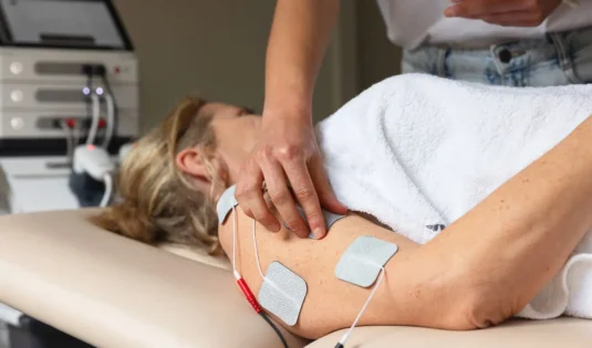 TENS terapija z elektrodami na rami pacientke